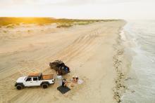 Group of people sitting around a campfire on a remote North Carolina beach