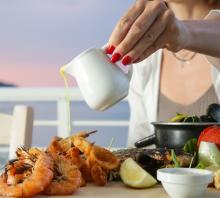 woman eating seafood dinner on the beach