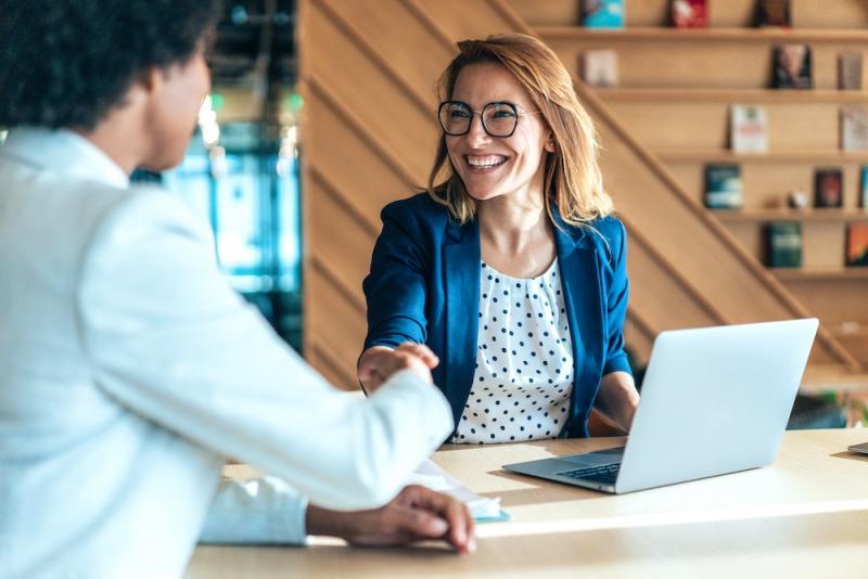 woman shaking hands with man in a meeting