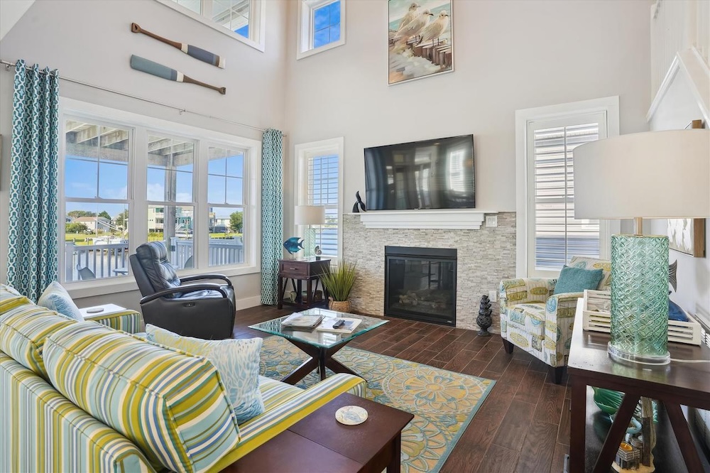 A spacious vacation rental interior with a large TV and fireplace
