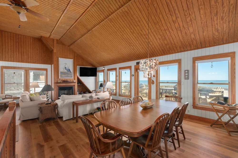 Vacation rental interior with hardwood floors, ocean window views, and coastal decor