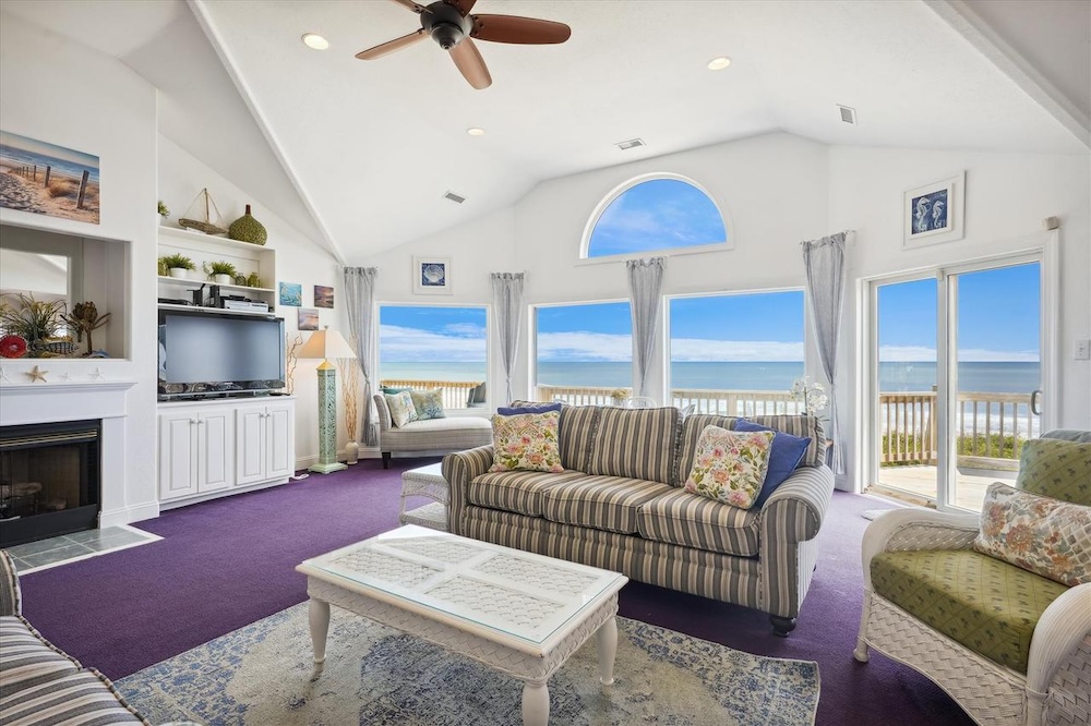 Vacation rental interior with deck and ocean view visible in background