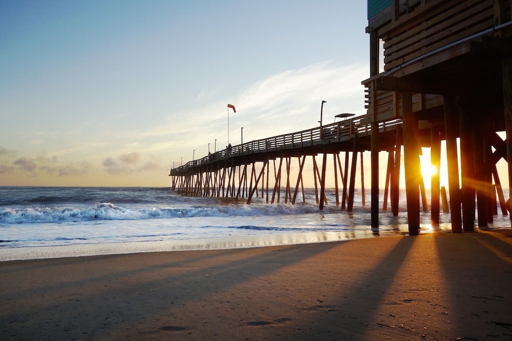 Beach and pier with sunrise in the background