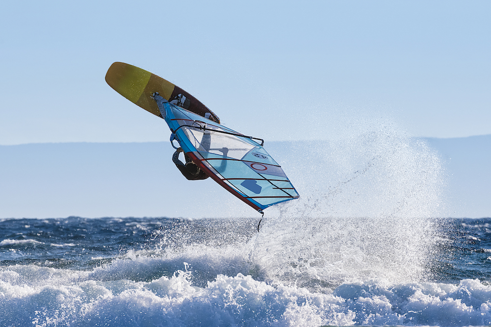 Windsurfer riding waves and jumping